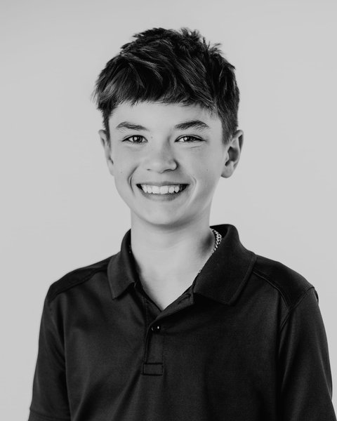 black and white school portrait of a boy in a navy polo, Denver