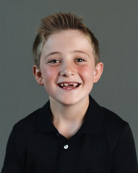 school picture day portrait of a boy in a black polo with a missing tooth, Denver Colorado